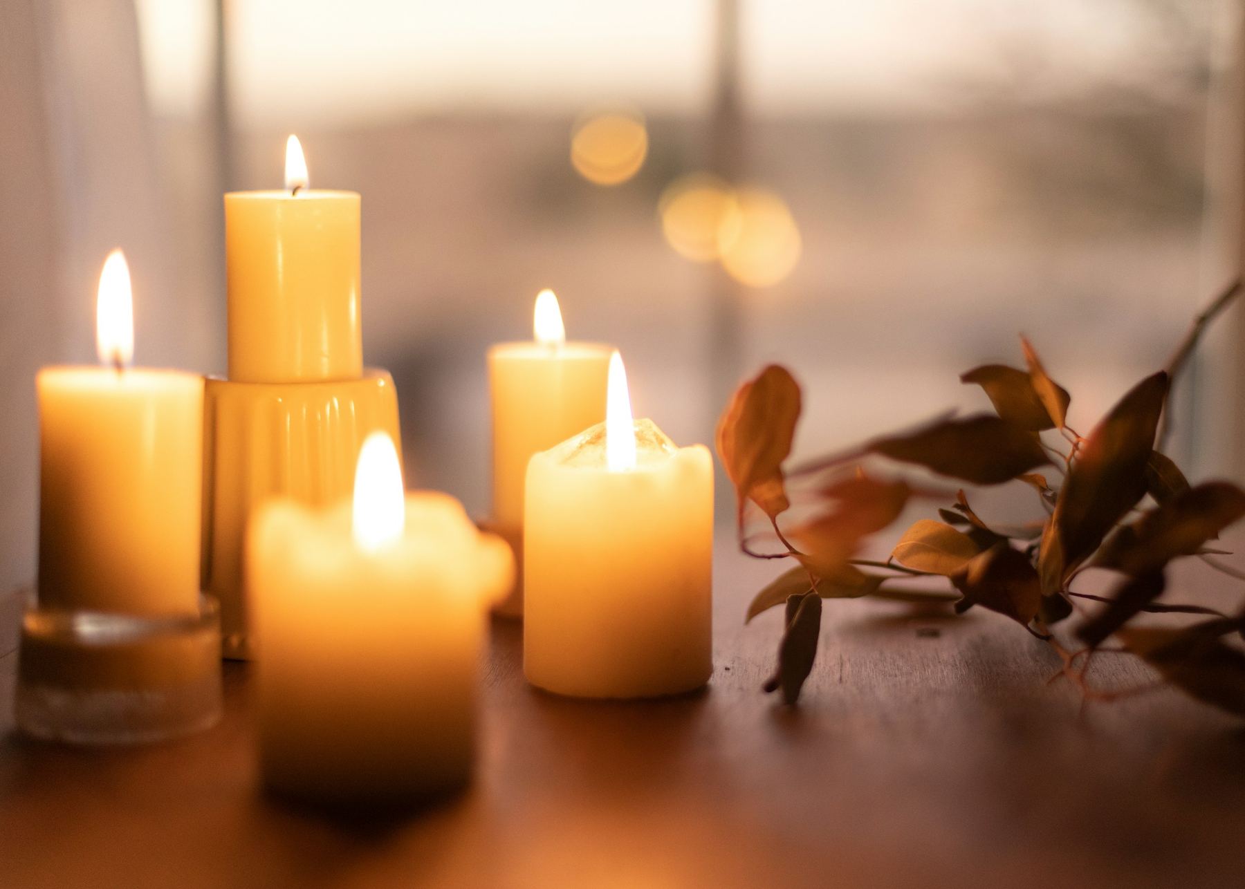 Warm candles glowing on a table at dusk