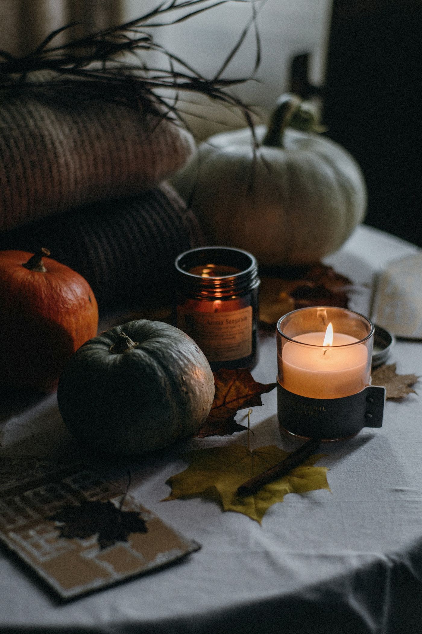 A cozy candle-lit table with books and knits